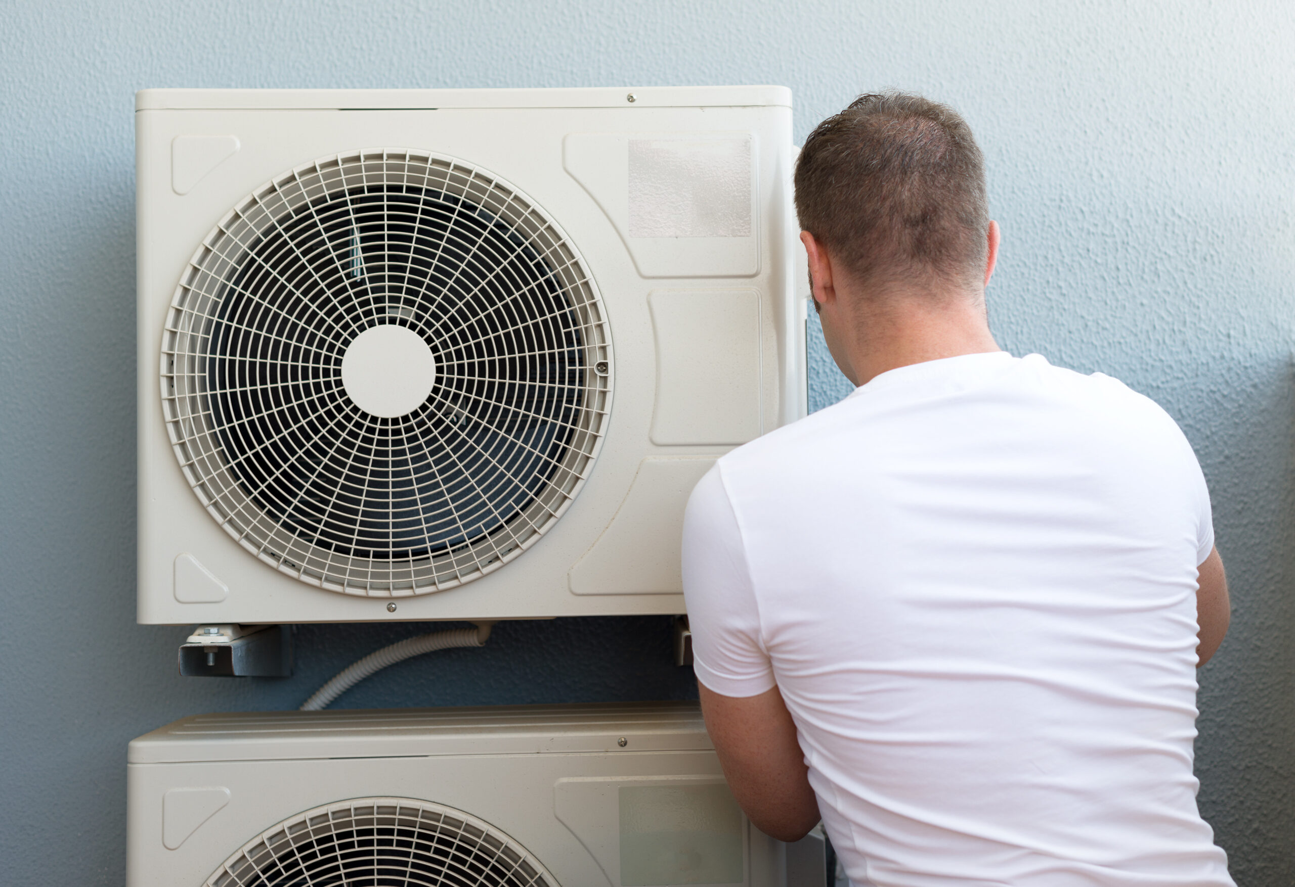 Male Technician Installing Air Conditioning System.